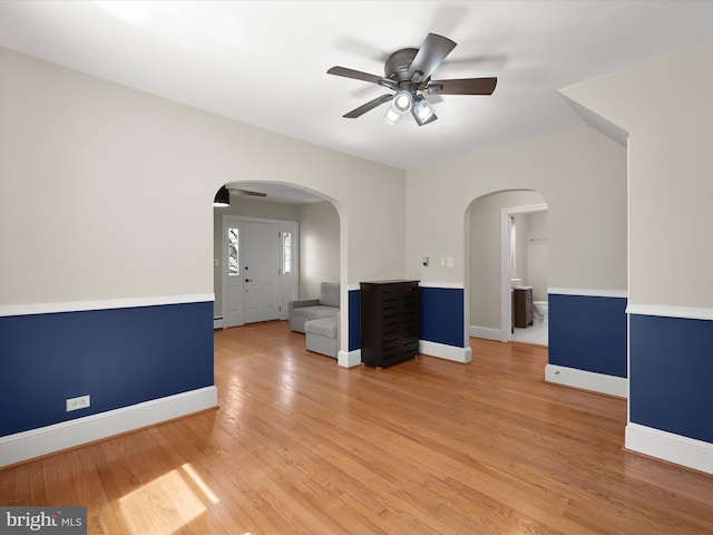 empty room featuring baseboards, a ceiling fan, and light wood-type flooring