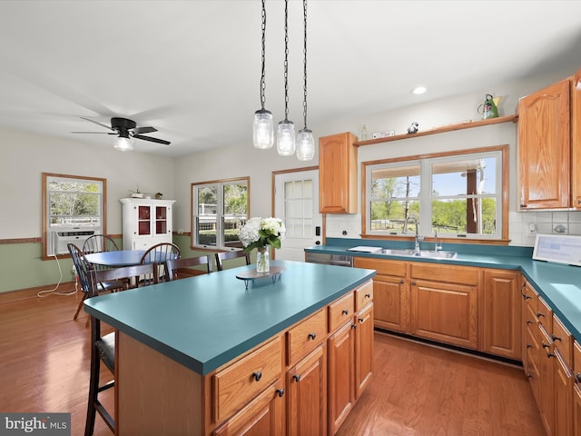 kitchen with decorative backsplash, a healthy amount of sunlight, a sink, and a breakfast bar