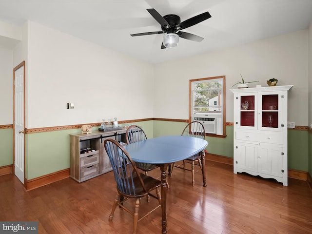 dining room featuring baseboards, wood finished floors, a ceiling fan, and cooling unit