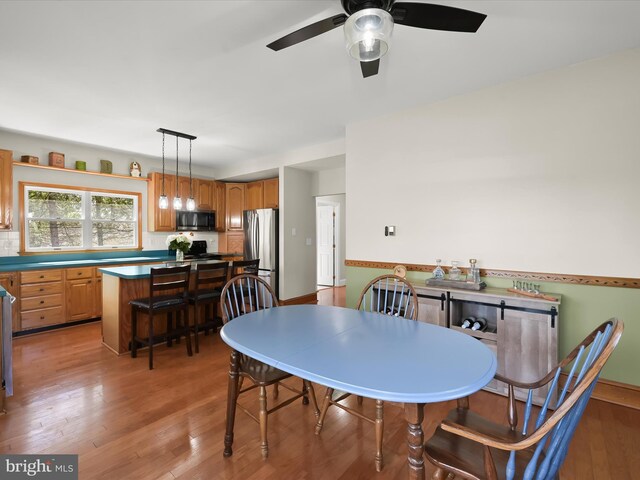 dining area featuring light wood-style floors and a ceiling fan