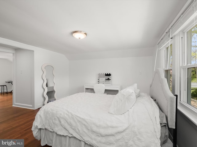 bedroom featuring multiple windows, baseboards, and dark wood-style flooring