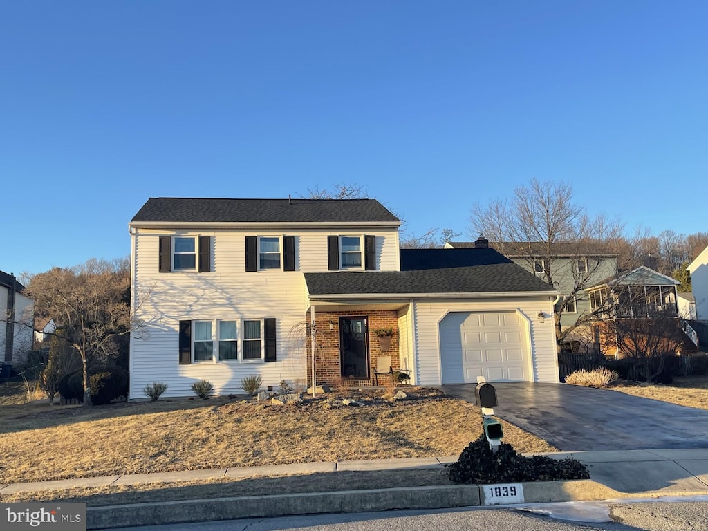 traditional home with a garage, concrete driveway, and brick siding