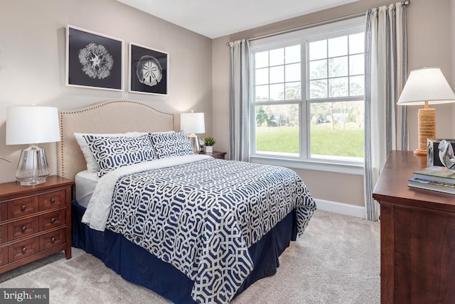 bedroom featuring light carpet and baseboards