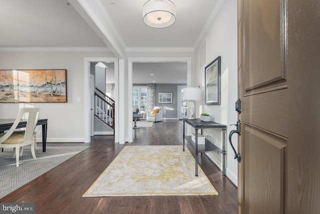 foyer entrance with crown molding, dark wood finished floors, stairway, and baseboards