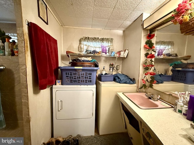 washroom with washing machine and dryer and a sink