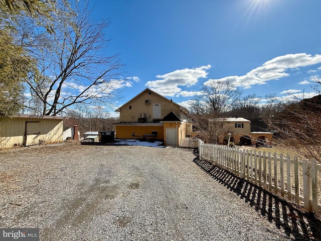 view of side of property featuring fence and driveway