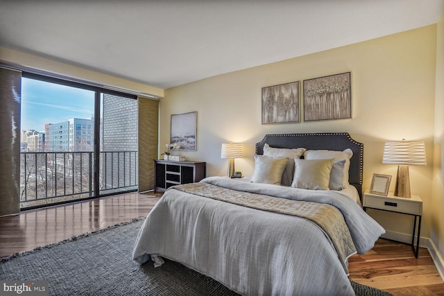 bedroom with access to outside, baseboards, and wood finished floors