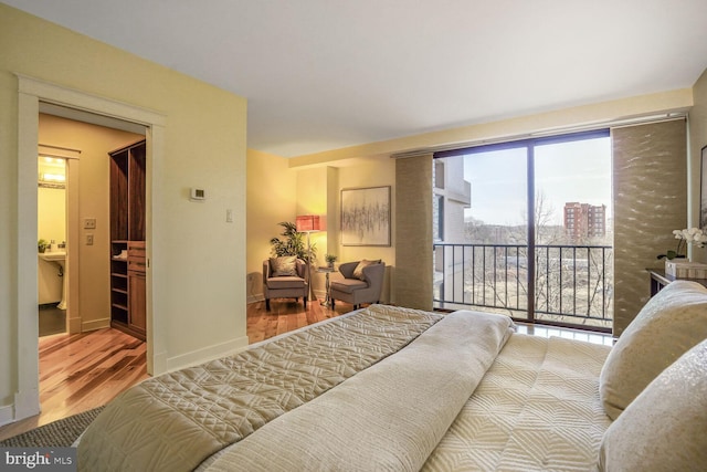 bedroom with access to outside, baseboards, and wood finished floors