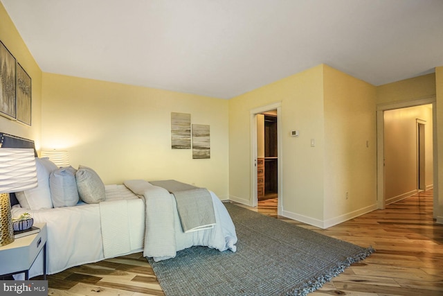 bedroom featuring wood finished floors and baseboards