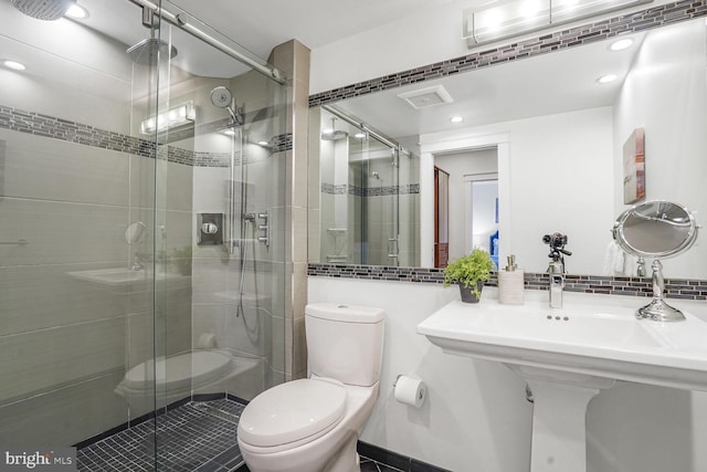 full bathroom with tasteful backsplash, a shower stall, and toilet