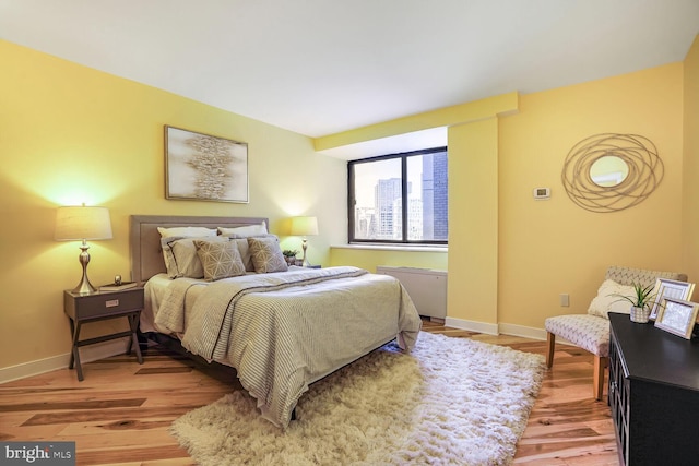 bedroom with light wood finished floors and baseboards