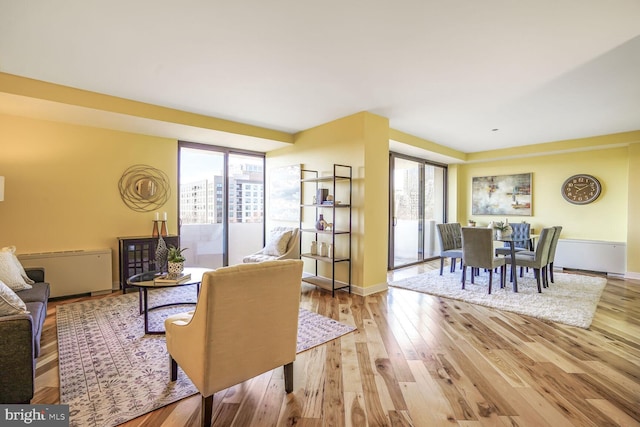 living area with baseboards and wood finished floors