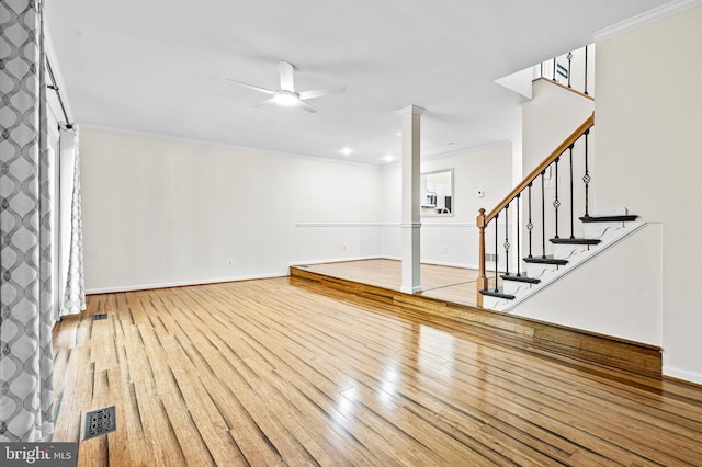 below grade area featuring visible vents, ornamental molding, a ceiling fan, and hardwood / wood-style flooring