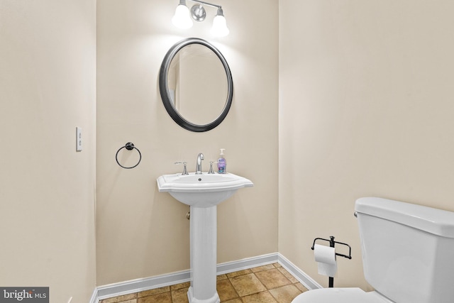 bathroom with baseboards and toilet