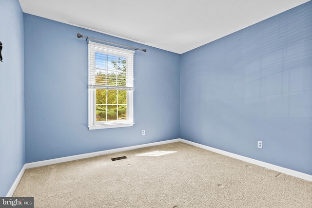 carpeted spare room with baseboards and visible vents