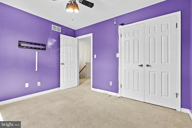 unfurnished bedroom featuring visible vents, baseboards, carpet floors, and a closet