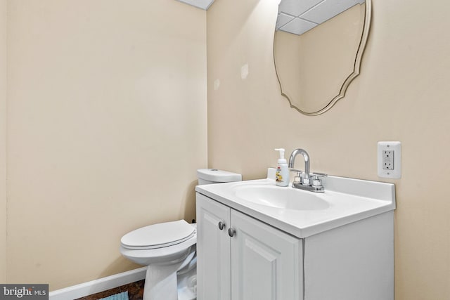 bathroom with vanity, baseboards, and toilet