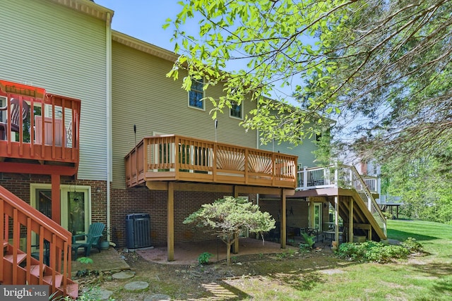 rear view of house with a wooden deck, central AC, stairway, and brick siding