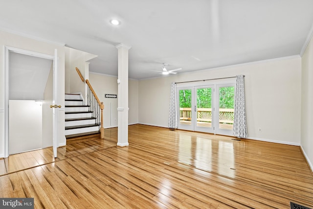 unfurnished living room featuring ornamental molding, hardwood / wood-style floors, baseboards, ceiling fan, and stairway