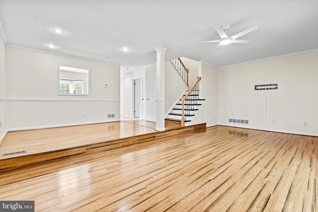 unfurnished living room featuring visible vents, crown molding, and wood finished floors