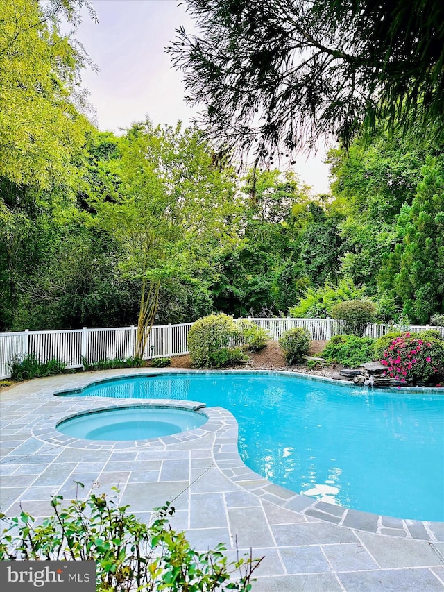 view of swimming pool featuring fence, an in ground hot tub, a fenced in pool, and a patio area