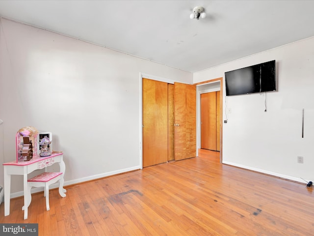 bedroom featuring hardwood / wood-style floors, a closet, and baseboards