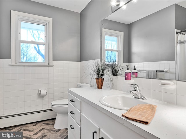 bathroom featuring a baseboard radiator, plenty of natural light, tile walls, and toilet