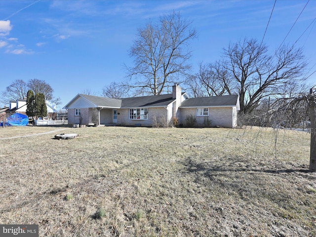 ranch-style house with a chimney and a front yard