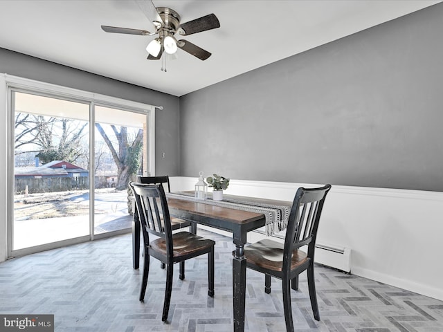 dining area featuring a baseboard radiator and a ceiling fan