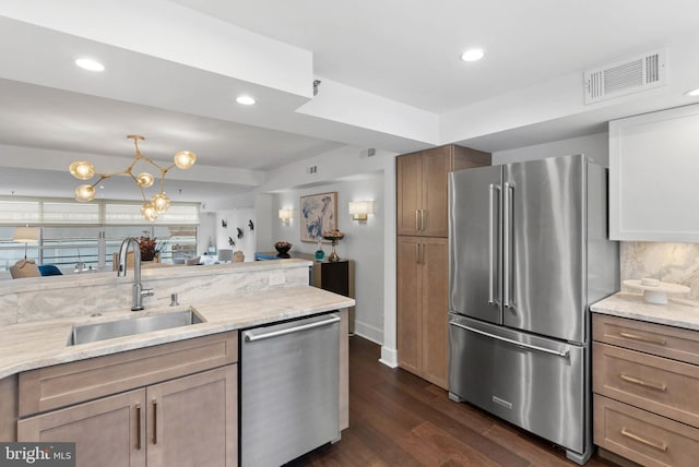 kitchen featuring dark wood finished floors, visible vents, decorative backsplash, appliances with stainless steel finishes, and a sink