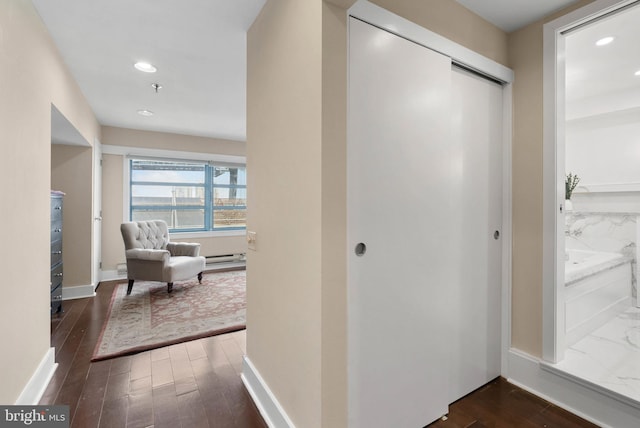 interior space with dark wood-type flooring, recessed lighting, a baseboard heating unit, and baseboards