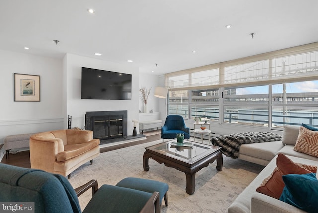 living area featuring a glass covered fireplace and recessed lighting