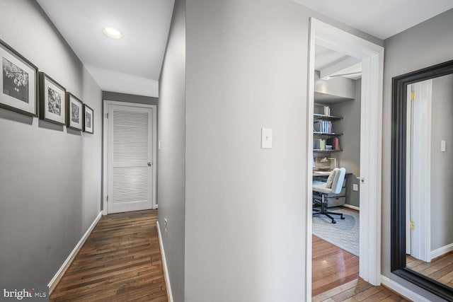 hallway featuring baseboards and dark wood-style flooring