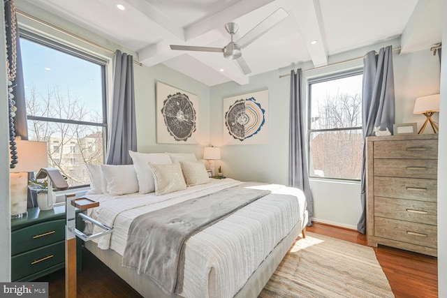 bedroom featuring recessed lighting, beamed ceiling, multiple windows, and wood finished floors