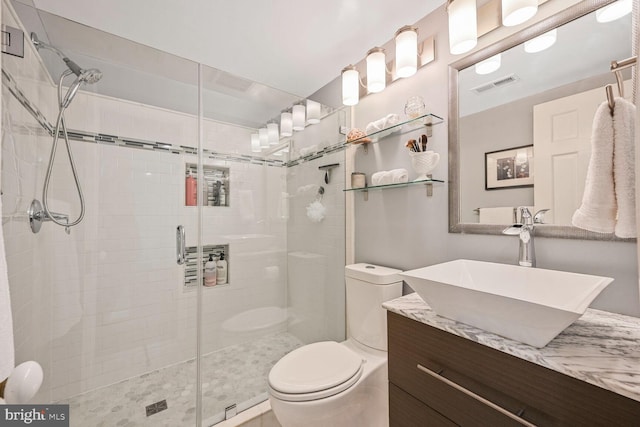 bathroom with visible vents, toilet, a stall shower, and vanity