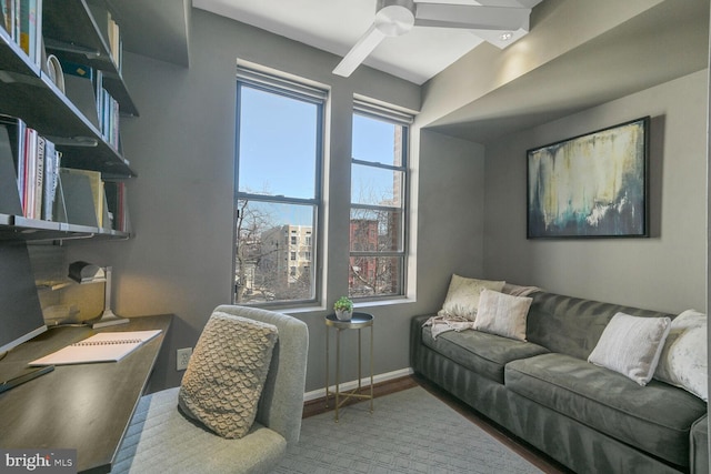 interior space with a ceiling fan, baseboards, and wood finished floors