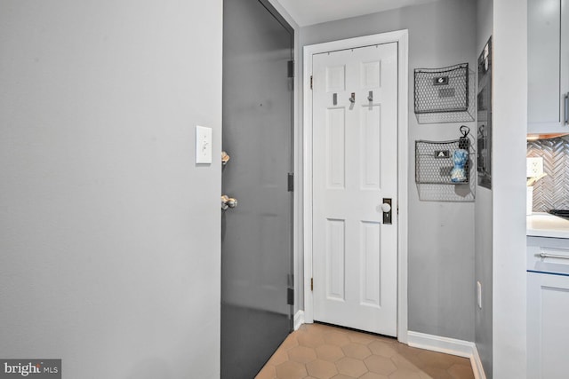 doorway to outside with tile patterned floors and baseboards