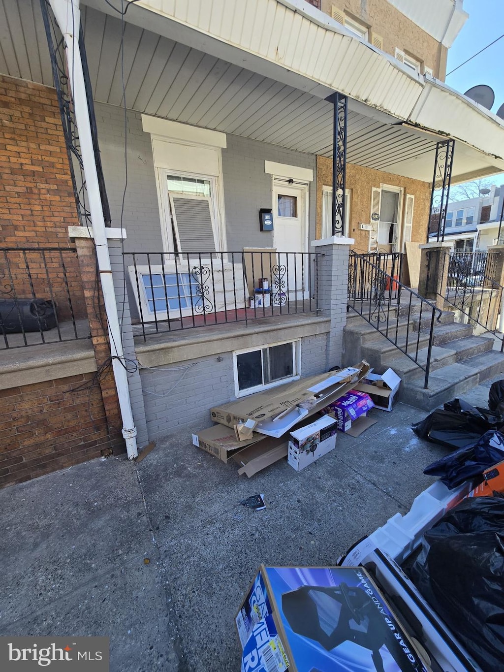 exterior space with a porch and brick siding