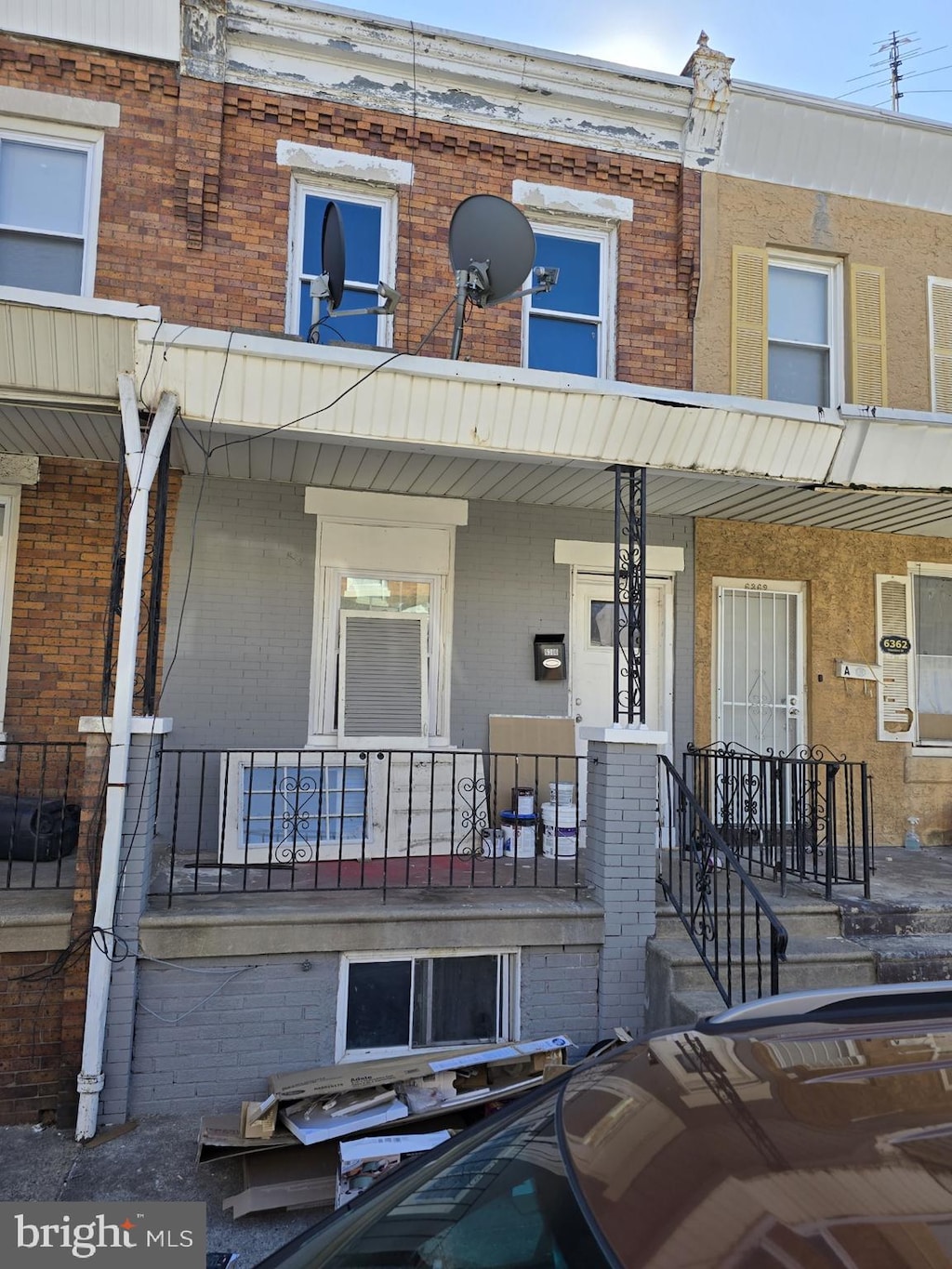 multi unit property with a porch and brick siding