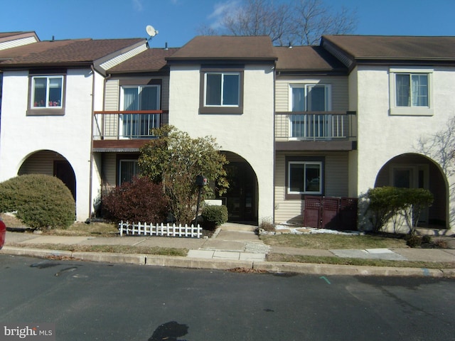 view of property featuring a balcony and stucco siding