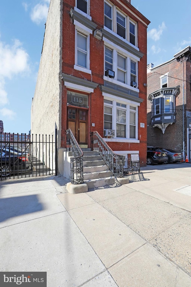 townhome / multi-family property featuring brick siding and fence