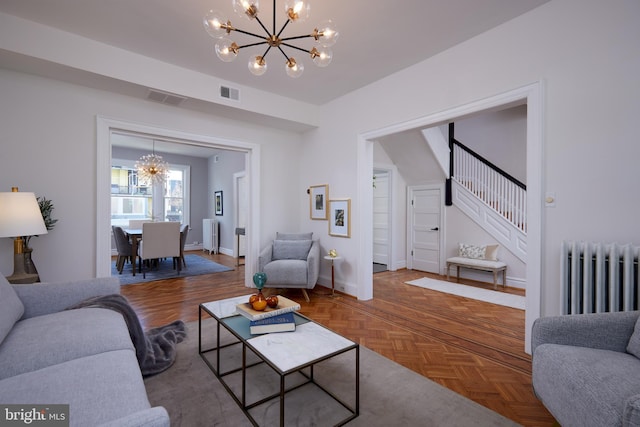 living area featuring a chandelier, visible vents, stairway, and radiator heating unit