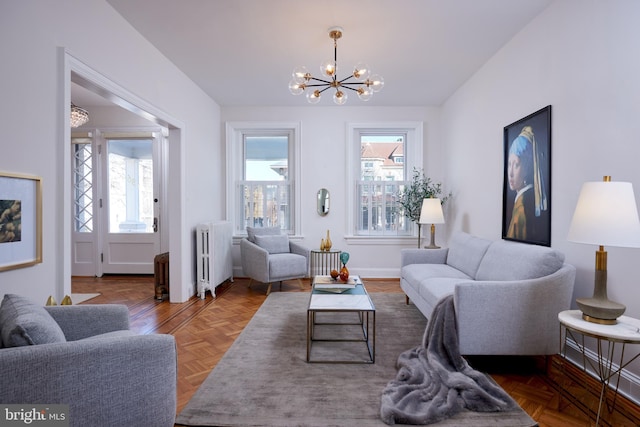 living room featuring radiator, an inviting chandelier, and baseboards