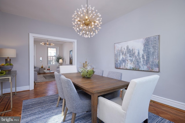 dining space featuring a chandelier and baseboards