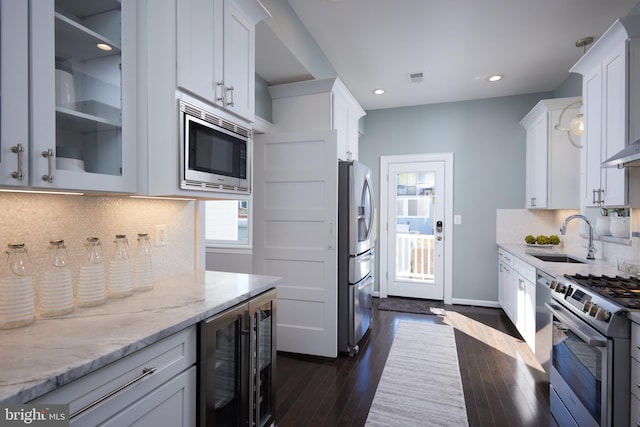 kitchen with white cabinetry, glass insert cabinets, stainless steel appliances, and a sink