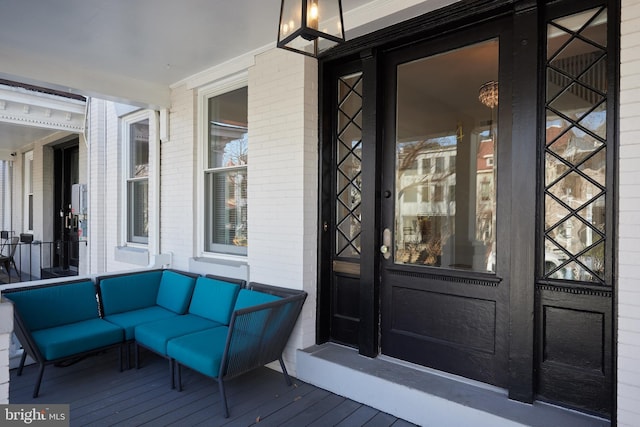 entrance to property featuring an outdoor living space and brick siding