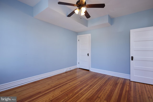 empty room with ceiling fan, baseboards, and hardwood / wood-style floors