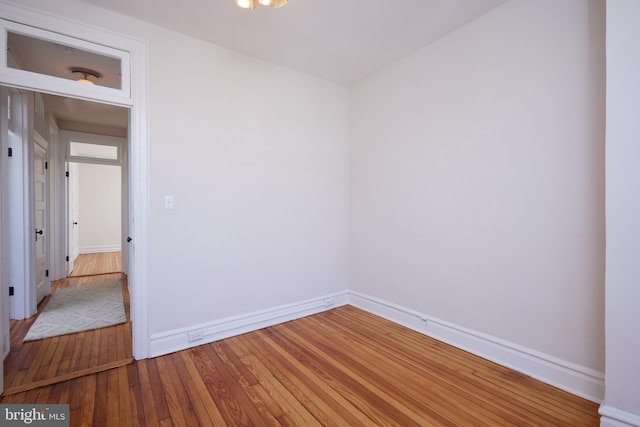 empty room with hardwood / wood-style flooring and baseboards