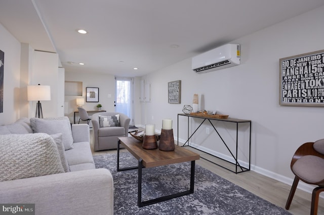 living room featuring light wood-style flooring, baseboards, an AC wall unit, and recessed lighting