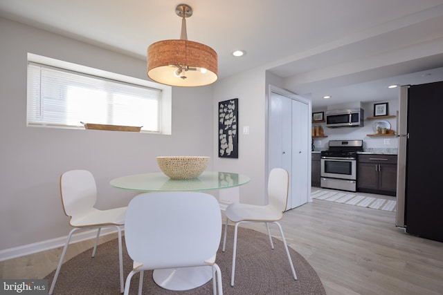 dining room with light wood-type flooring, baseboards, and recessed lighting